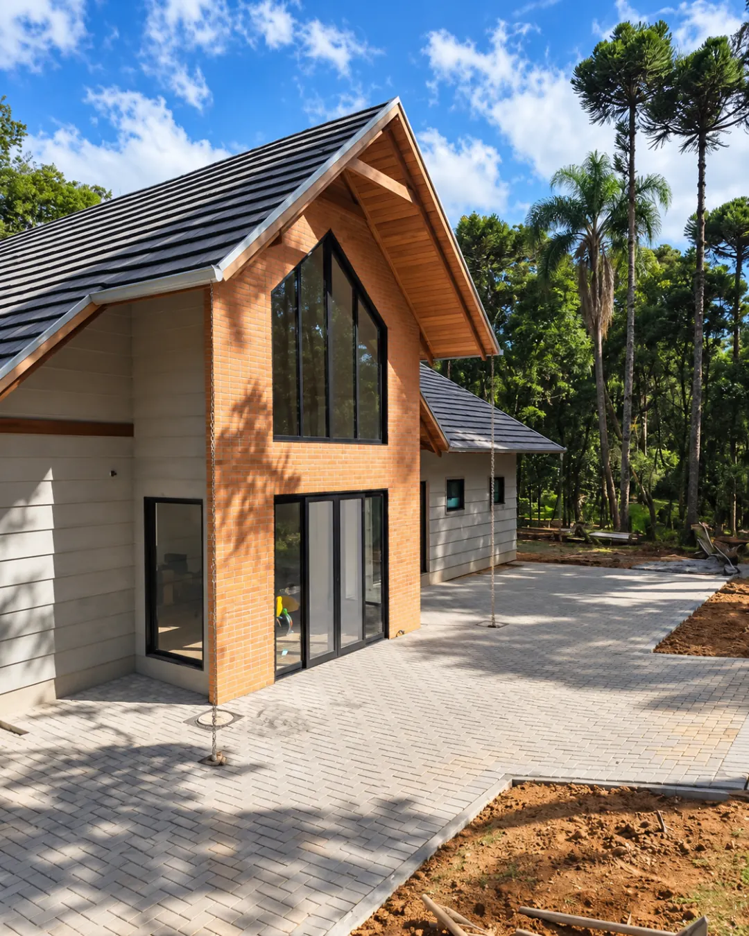 Calçada em paver ao redor de casa com fachada de tijolo