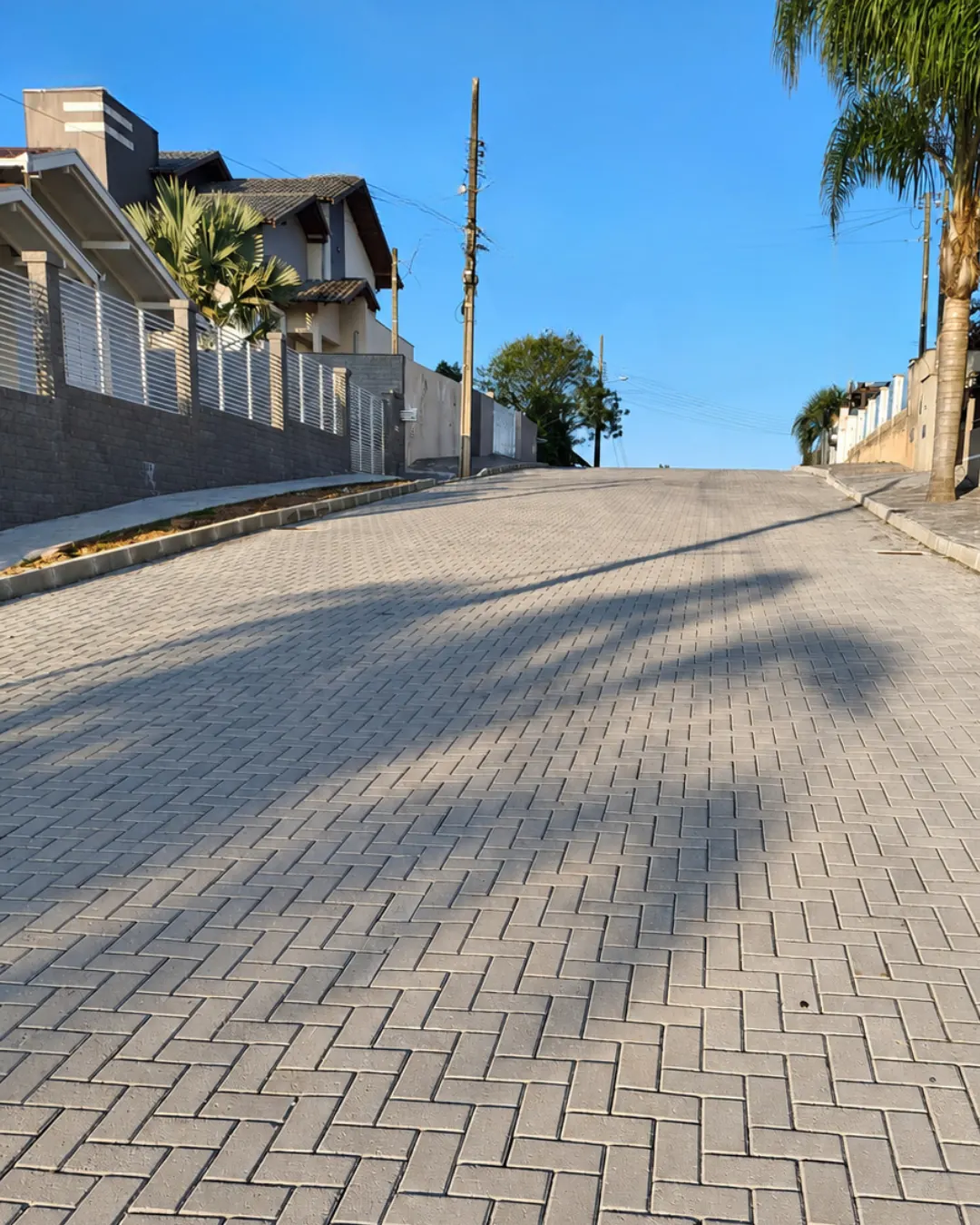 Rua residencial em aclive pavimentada com paver